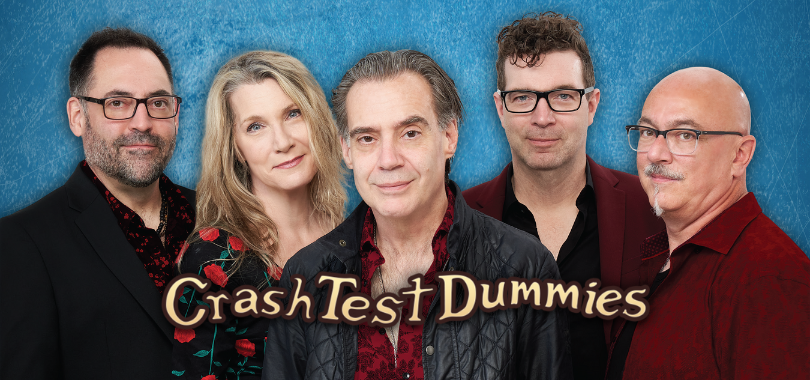 The five members of Crash Test Dummies pose in a line against a blue background.