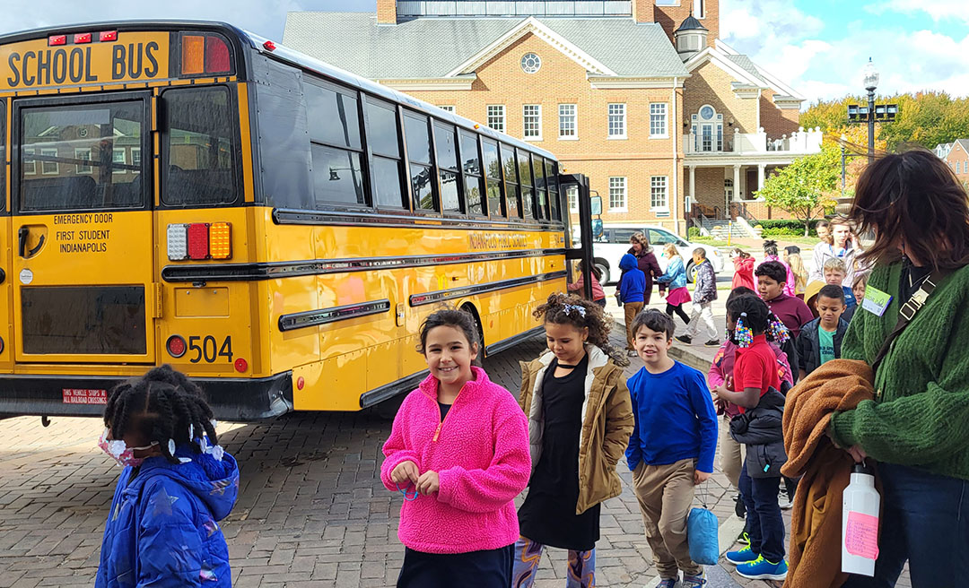 Young students disembark from a school bus to attend an event at the Center for the Performing Arts.
