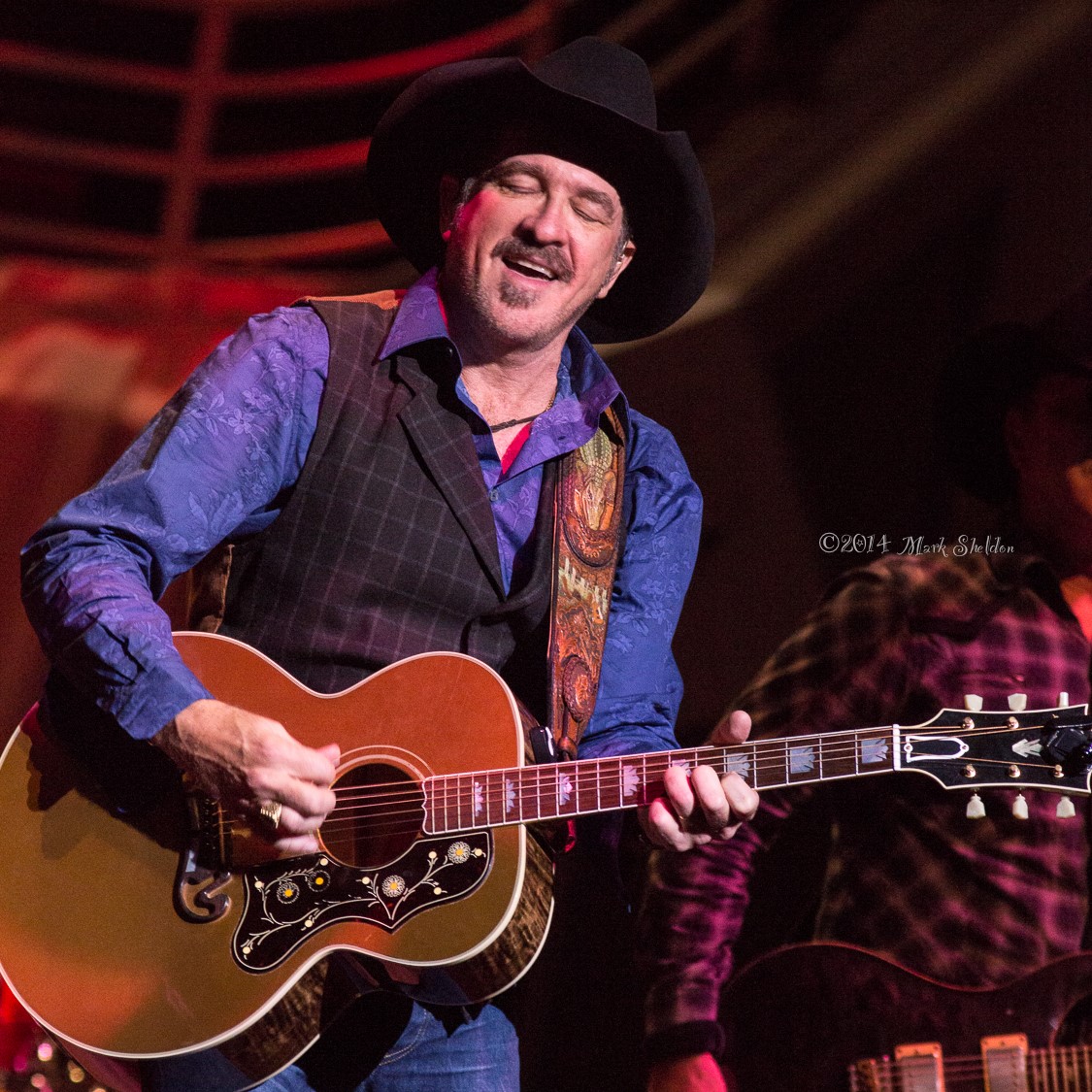 Wearing a cowboy hat, country star Kix Brooks plays an acoustic guitar on the Palladium stage..