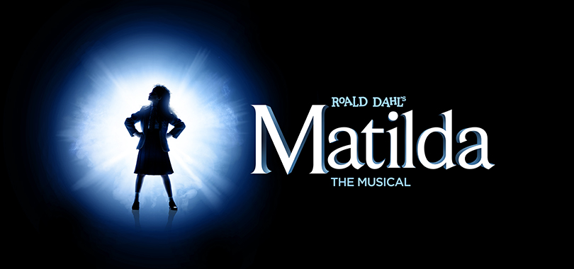 A girl is silhouetted against a blue-and-white starburst. Text reads "Roald Dahl's Matilda the Musical."