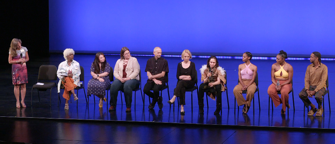 Nine artists seated onstage for a discussion