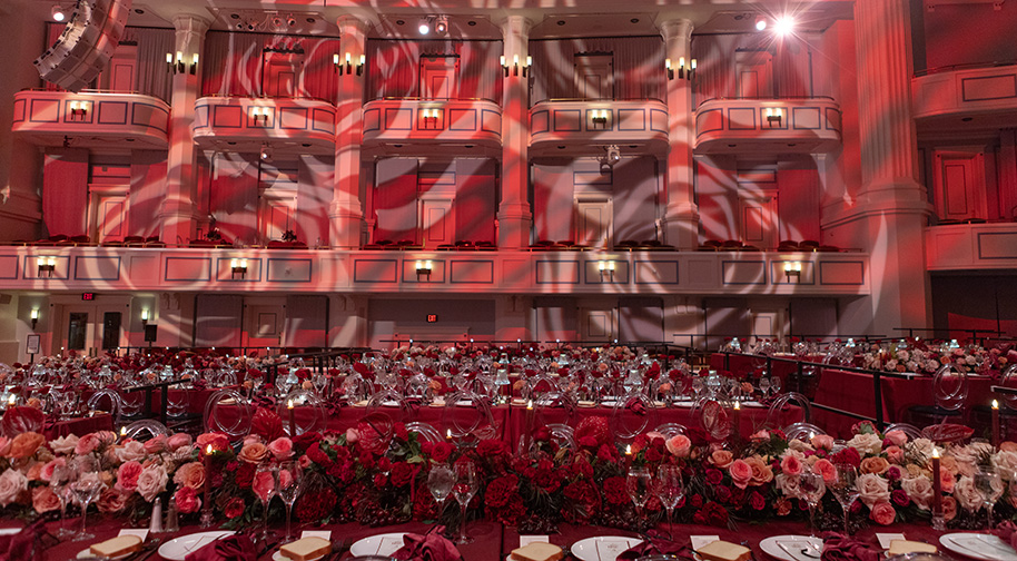 Tables on festival floor in the Payne & Mencias Palladium is lavishly decorated with roses and carnations.
