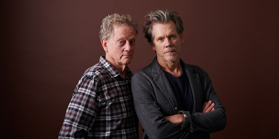 Michael and Kevin Bacon pose side by side against a leathery brown background.