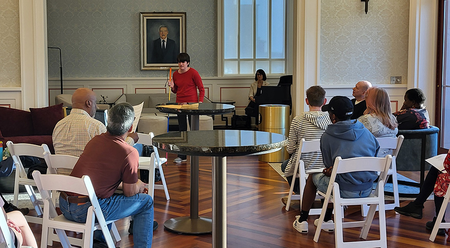 Students of various ages in the Group Vocal Coaching class watch as one performs solo.