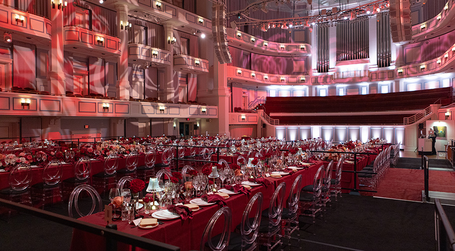 Festival Floor 4 Long dining tables decorated with roses and carnations set on the festival floor in the Payne & Mencias Palladium.
