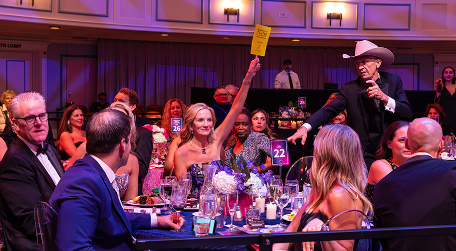 During a live auction, guests raise paddles to bid.