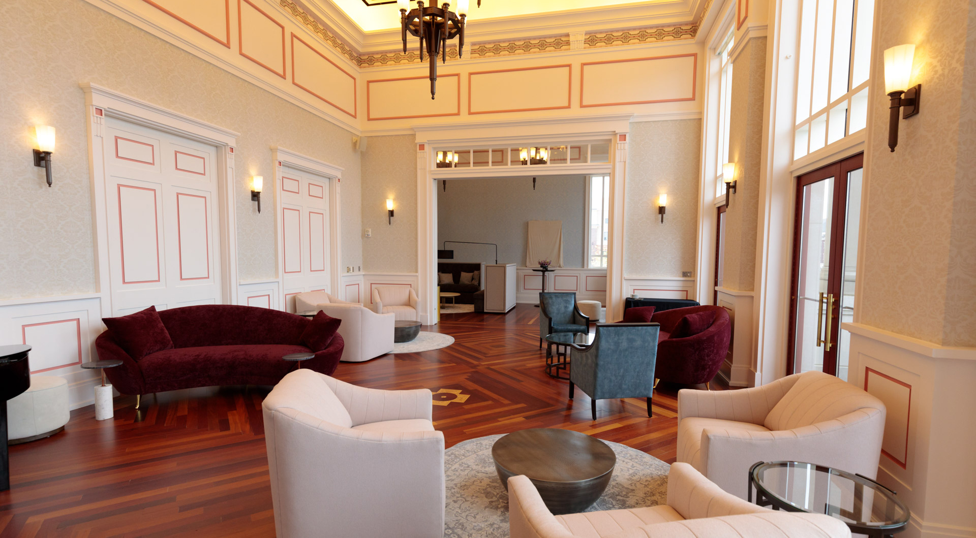 Brham Founders Club 2 The Founder's Club, an elegant lounge area with chandeliers, sconces, polished hardwood floors and plush furniture.