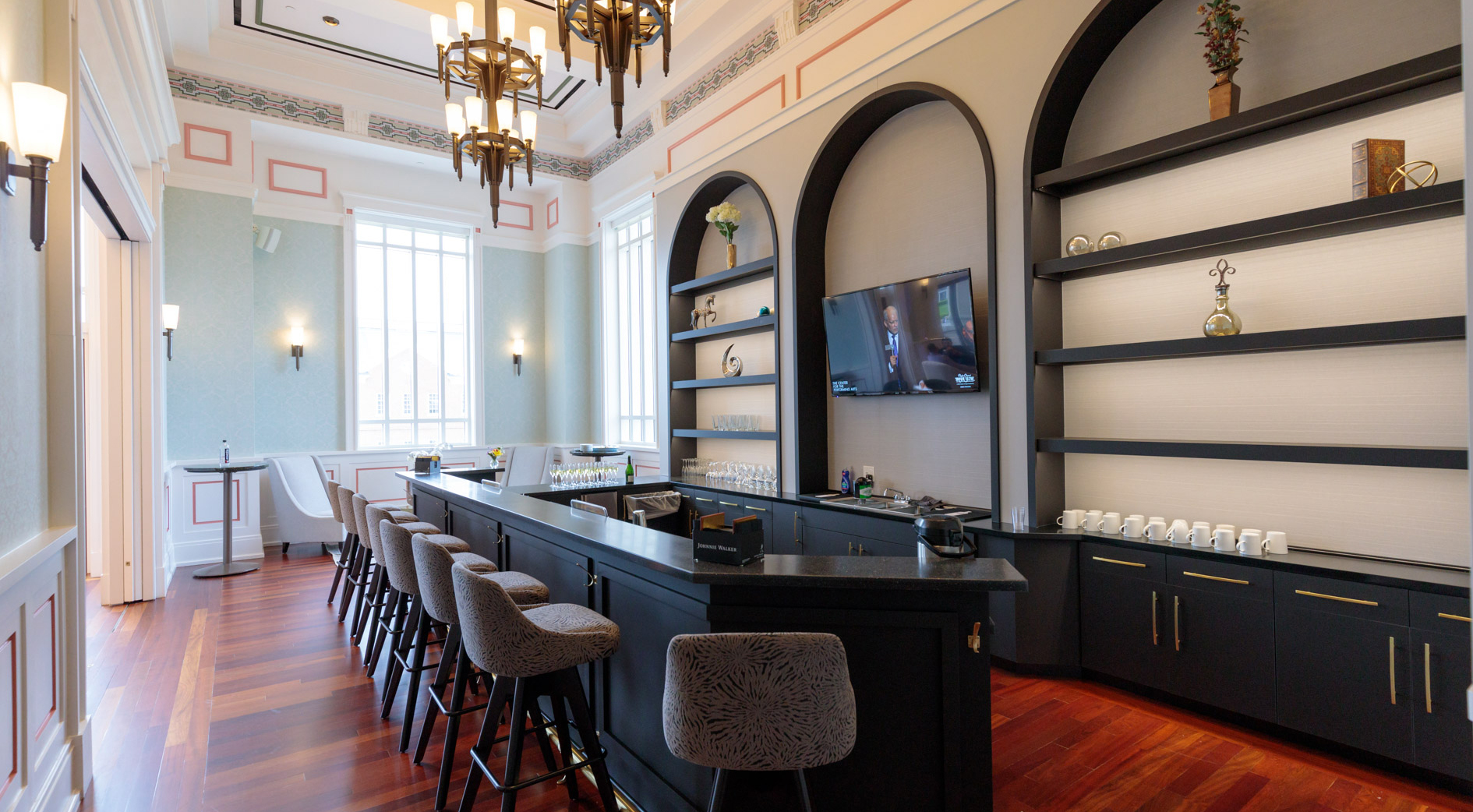 Brham Founders Club 1 An elegant bar with stools, chandeliers and polished hardwood flooring